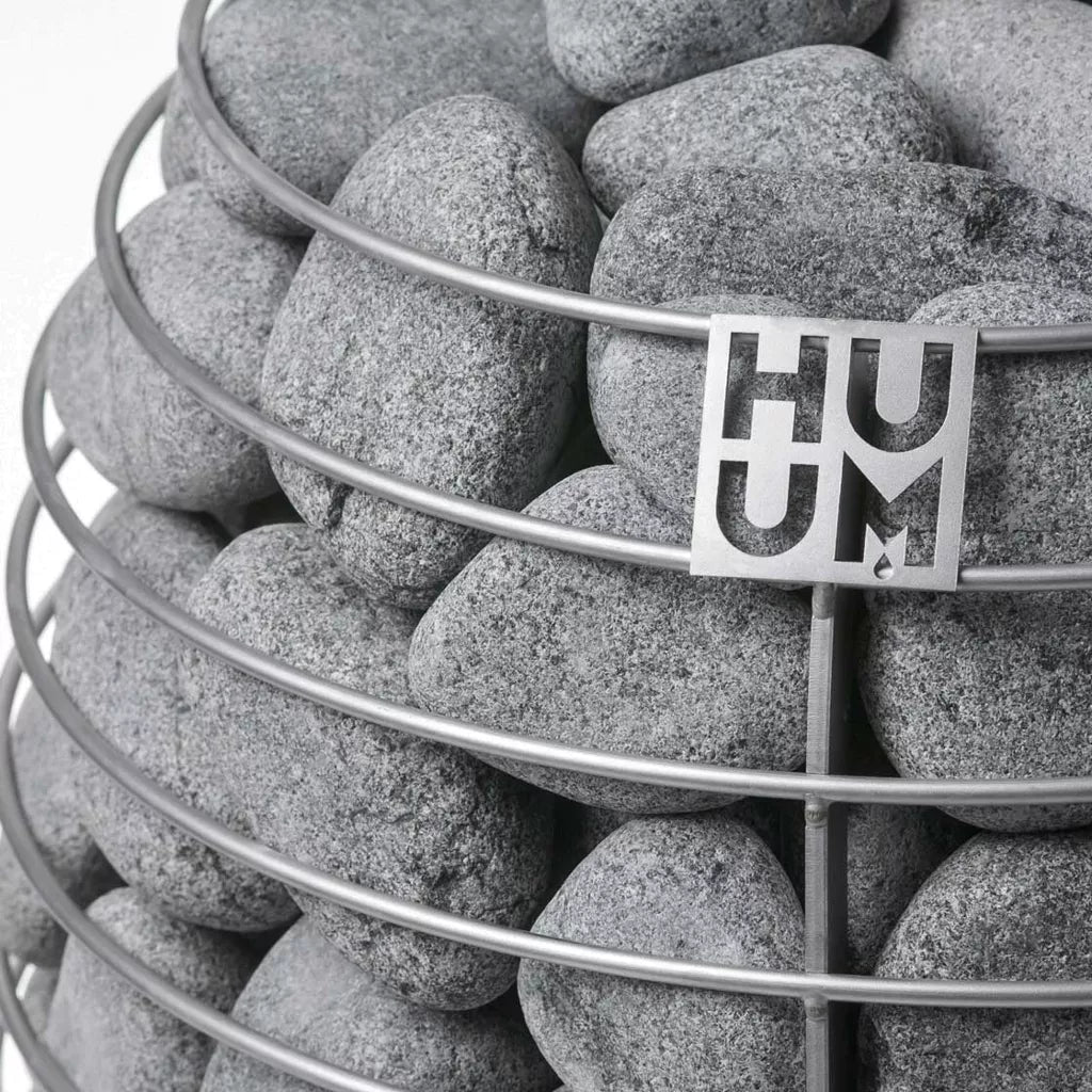 rounded grey stones enveloped by stainless steel frame of huum sauna heater