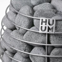 rounded grey stones enveloped by stainless steel frame of huum sauna heater