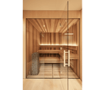 Lit up sauna with view through glass doors and huum cliff sauna heaters on the left hand side embedded into the bench