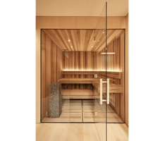 Lit up sauna with view through glass doors and huum cliff sauna heaters on the left hand side embedded into the bench