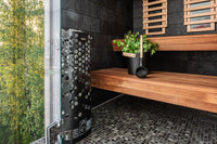 Helo Laine STJ black sauna heater situated near window of sauna looking out onto tree canopy
