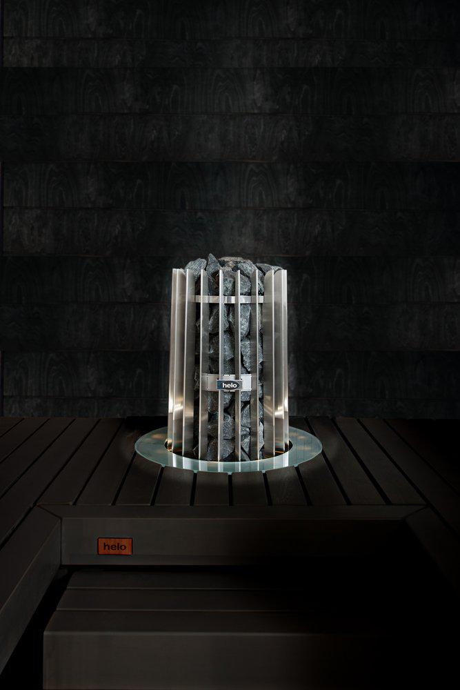 Helo Rocher Elite sauna heater embedded in dark coloured wood sauna bench with a stainless collar