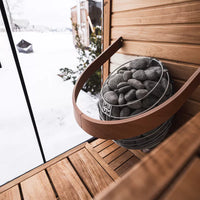 HUUM Drop sauna heater in light filled sauna with snowy background vista