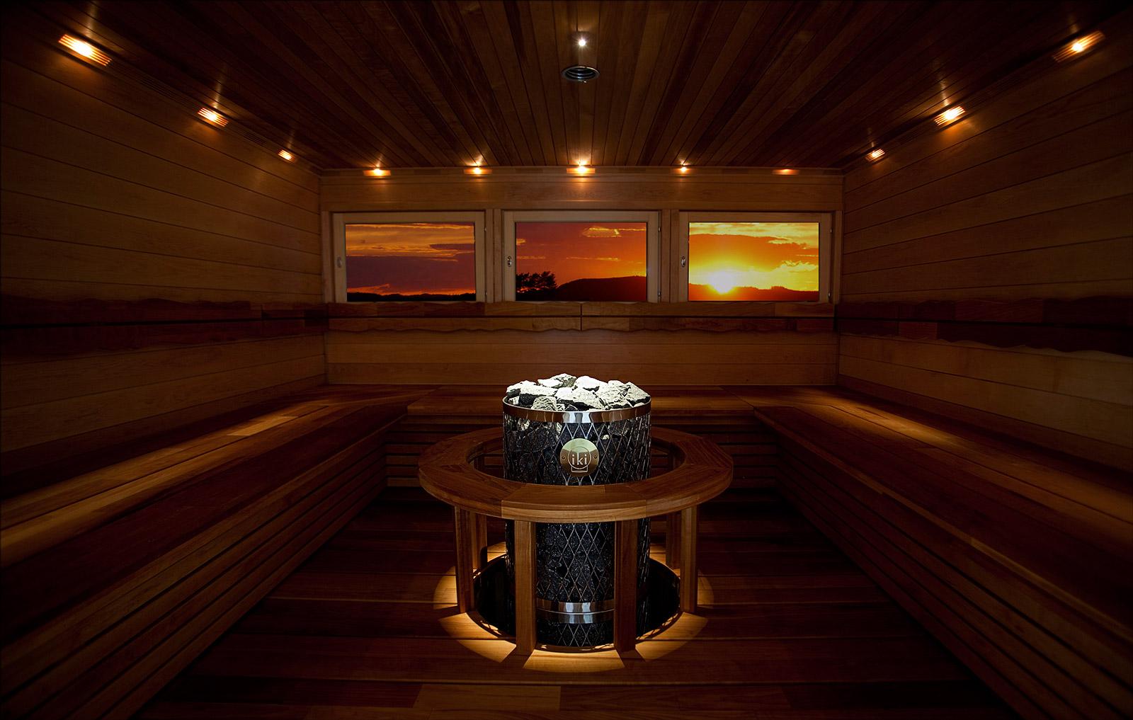 Interior of a sauna with embedded Iki Pillar sauna heater with scenic window views.