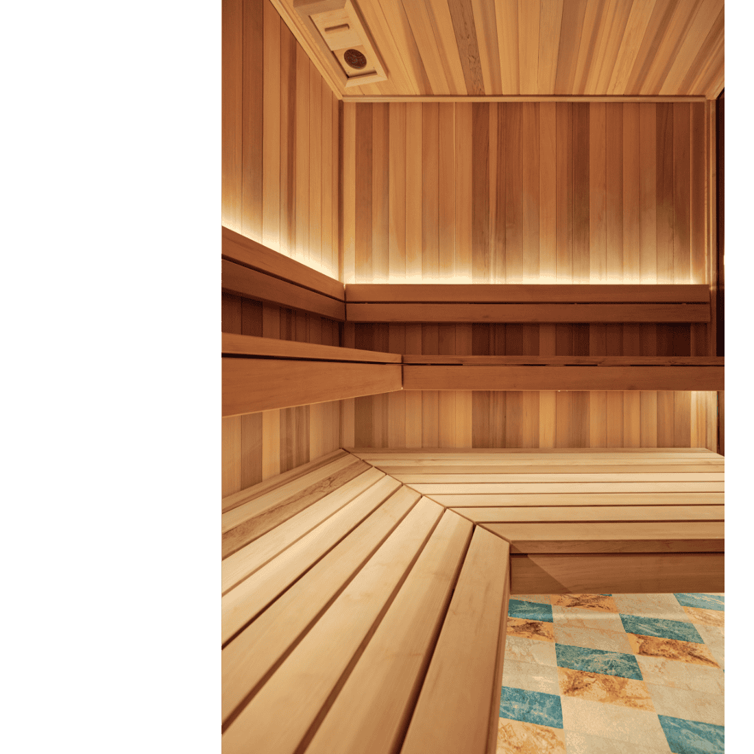 Wooden sauna interior with benches and a tiled floor.