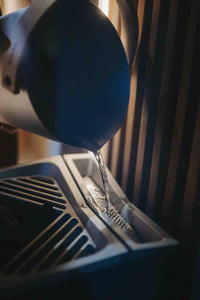 Water being poured onto top of Tylo Crown combi elite sauna heater