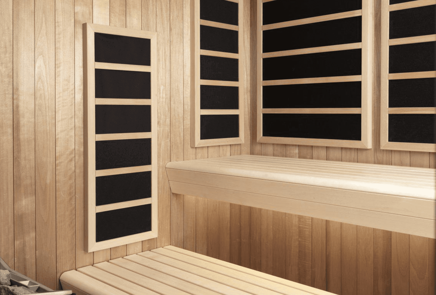 Wooden sauna interior with four black infrared panels on the walls