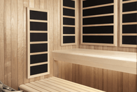 Wooden sauna interior with four black infrared panels on the walls